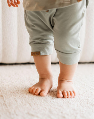 Les pieds nus d'un bébé sur un tapis.