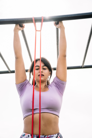 woman doing pull up bar with a pull up band