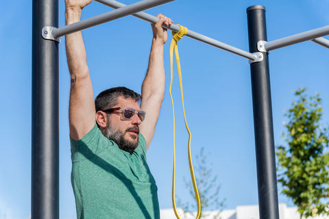 man holding off a pull up bar doing pull ups