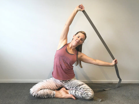 woman using yoga strap to stretch