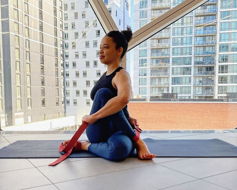 fit woman sitting on yoga mat and twisting body