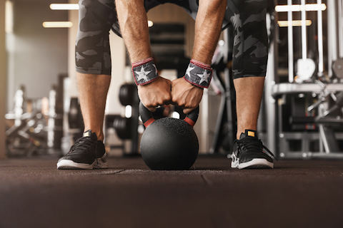man lifting kettlebell in the gym