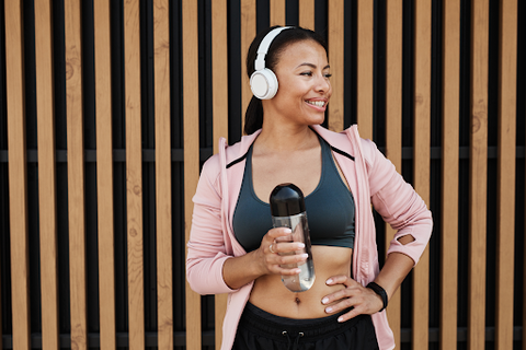 woman on gym attire and using headphones