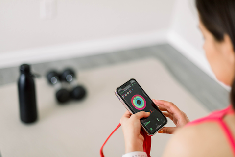 woman looking at fitness app on smartphone