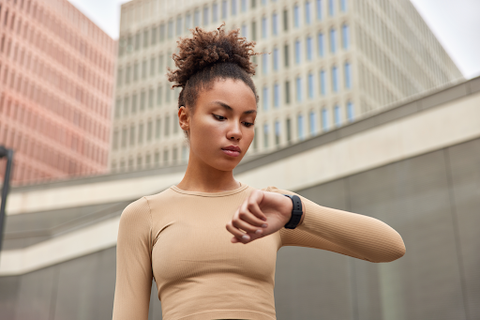 woman looking at watch while outside