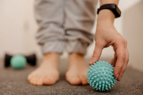 hand picking up spiky massage ball
