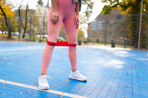 woman stretching legs with resistance bands