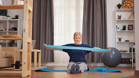 woman exercising in home with resistance bands