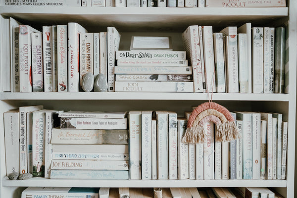 A close up of a bookshelf with all white book spines