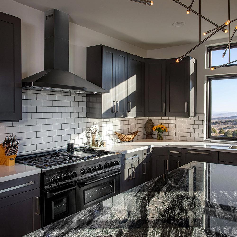 ZLINE black stainless steel range hood in a kitchen above a matching range