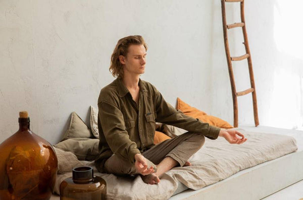 Man sitting on a bed meditating