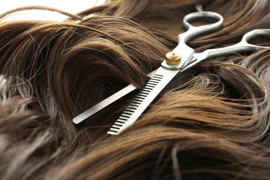 A hairdresser thinning out their clients hair with scissors