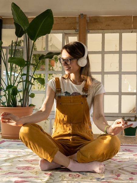 Girl meditating in a room with plants