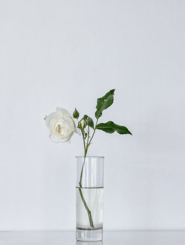 Flowers displayed in a drinking glass.