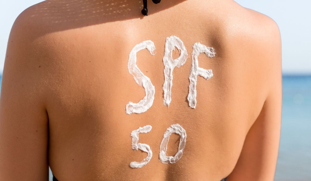 Woman with the sunscreen SPF 50 on her back