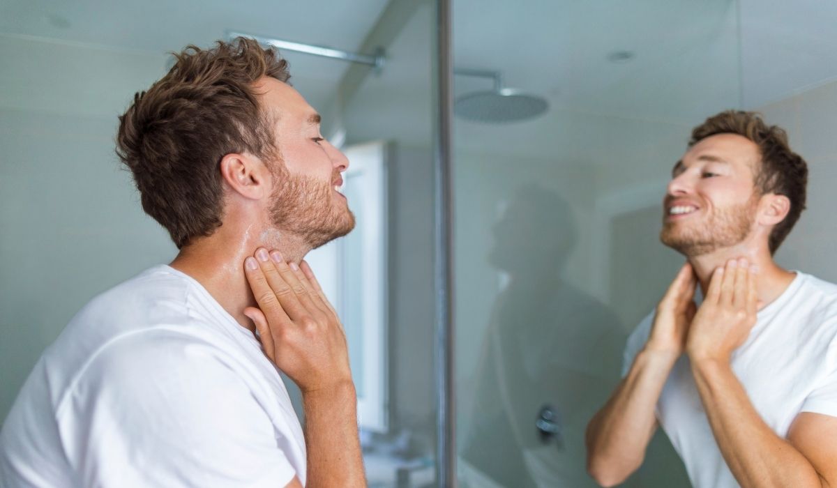 Man looking at himself to the mirror after shaving