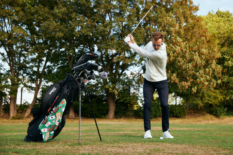 Golfer swinging in a golf hoodie