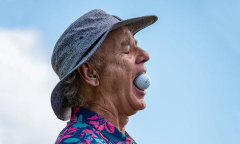 Bill Murray with golf ball in mouth