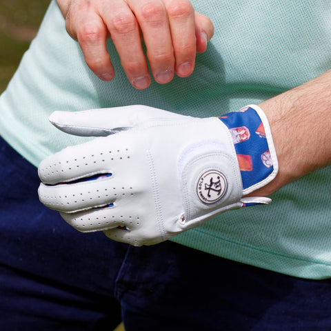 Golfer putting on whiskey themed golf glove