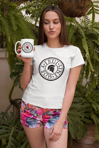young, pretty woman wearing nice shorts and a white t-shirt with a design of a large coin and a black Greek helmet inside, which is inscribed in big black capital letters Frui Sine Mora