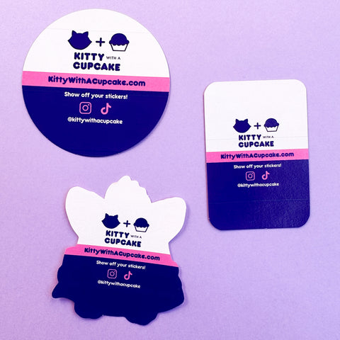 The back of stickers showing the new back paper branding featuring Kitty With A Cupcake colors and logos