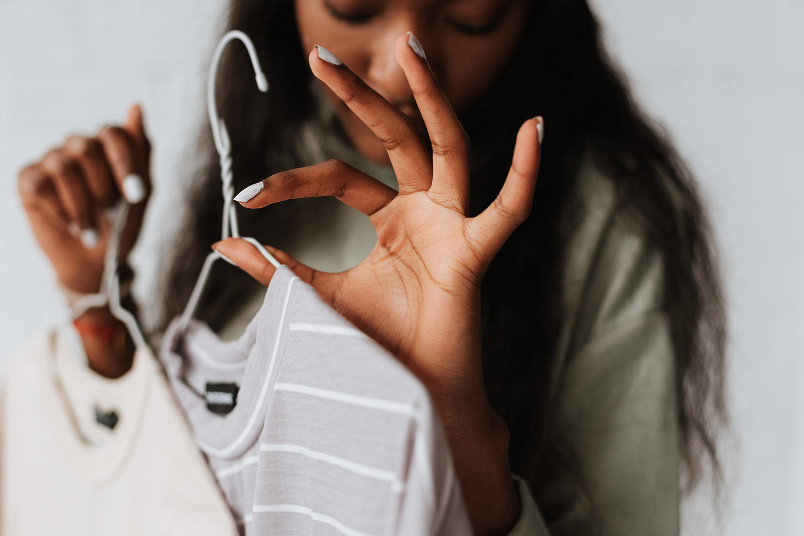 woman holding fashionable and stylish clothes on hanger