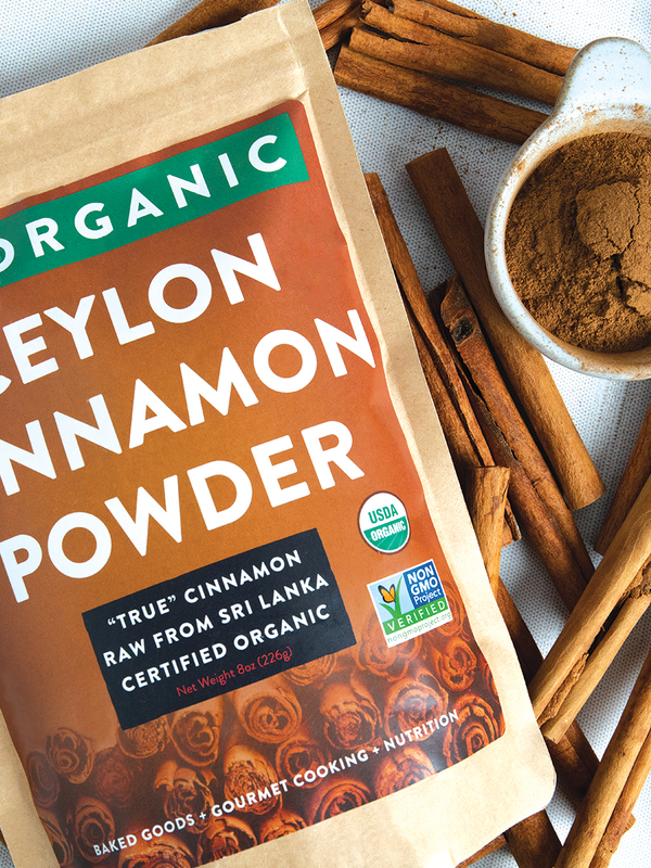"True" cinnamon sticks and a pile of raw ceylon cinnamon powder in a dish.