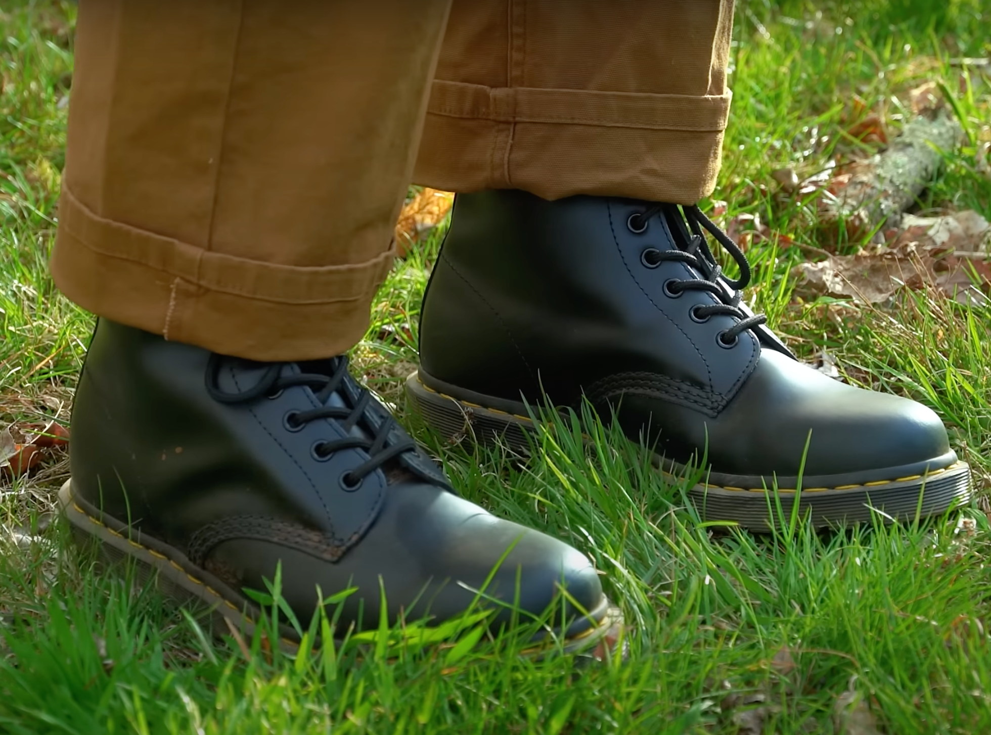 Dr. Martens 1460 Boots on someone's feet in the grass