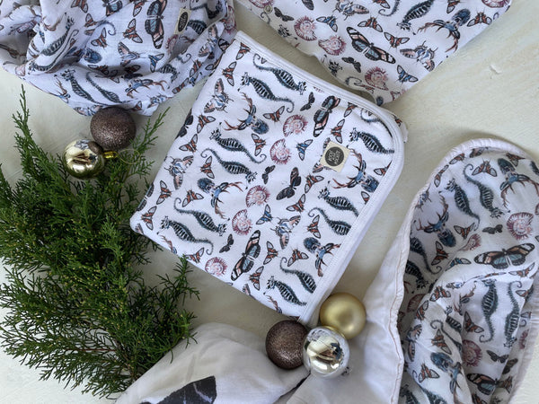 printed jersey blanket, quilted blanket and swaddles in flatlay with christmas decorations