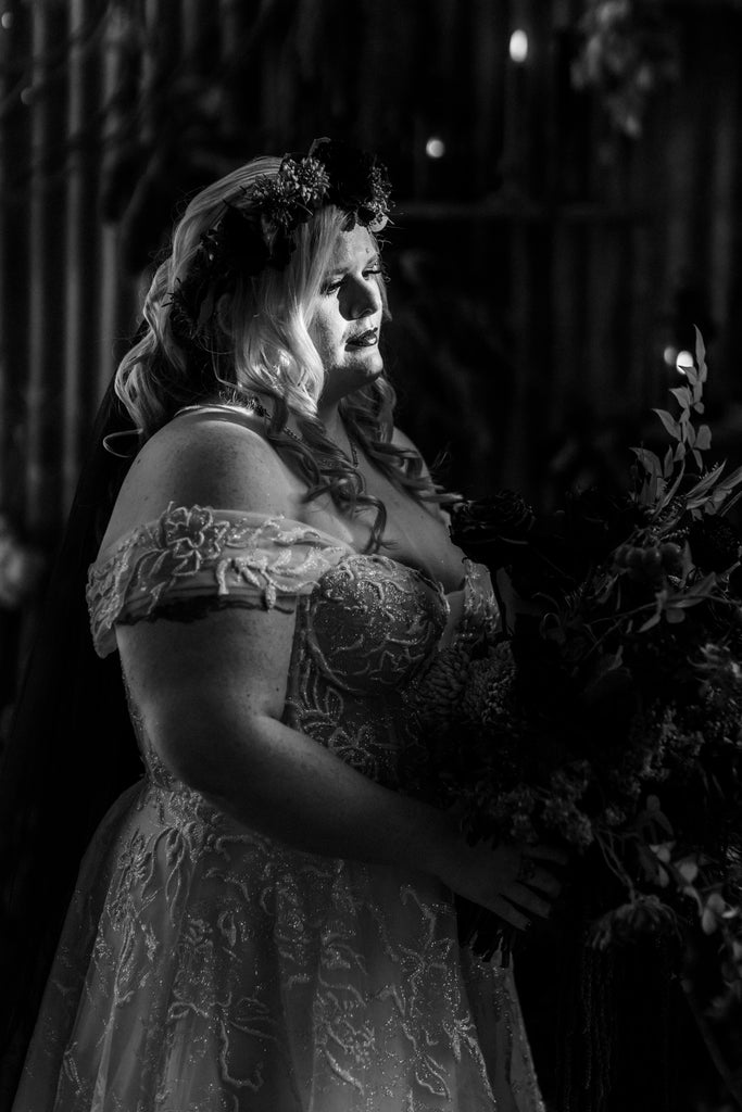 A black and white glamour shot of Chantelle, dressed in her beautiful wedding gown, flower crown and holding her bridal bouquet.