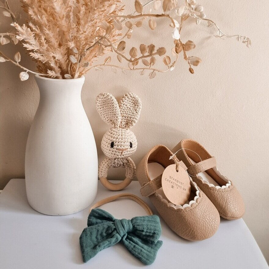 Beige Babyschuhe und Accessoires, die auf dem Tisch liegen