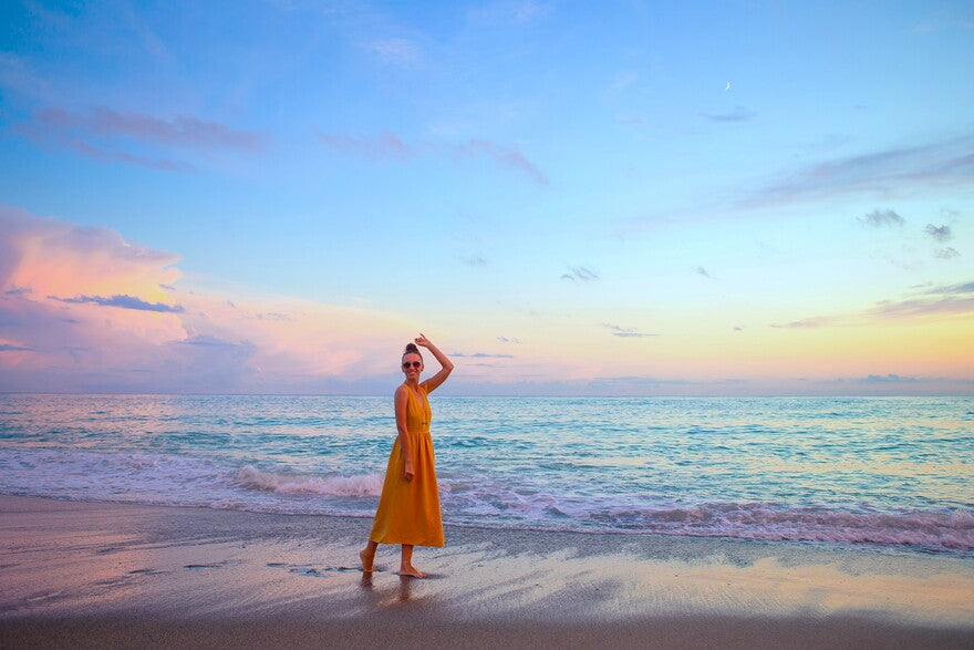 Frau steht am Strand genießt Sommerferien schaut Meer