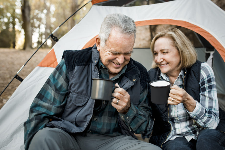 Glückliches älteres Paar beim Kaffeetrinken im Zeltwald