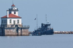 The LT-5, Major Elisha K. Henson US Army Boat on the water by Lighthouse from H Lee White Maritime Museum Oswego NY