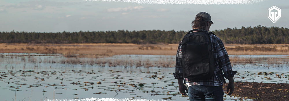 Man carrying a backpack in the outdoors near water