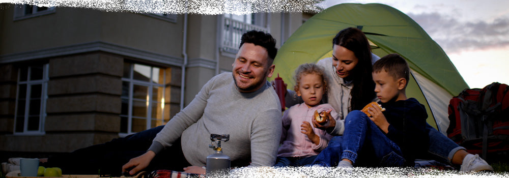 Family bonding outside their home camping with a small tent