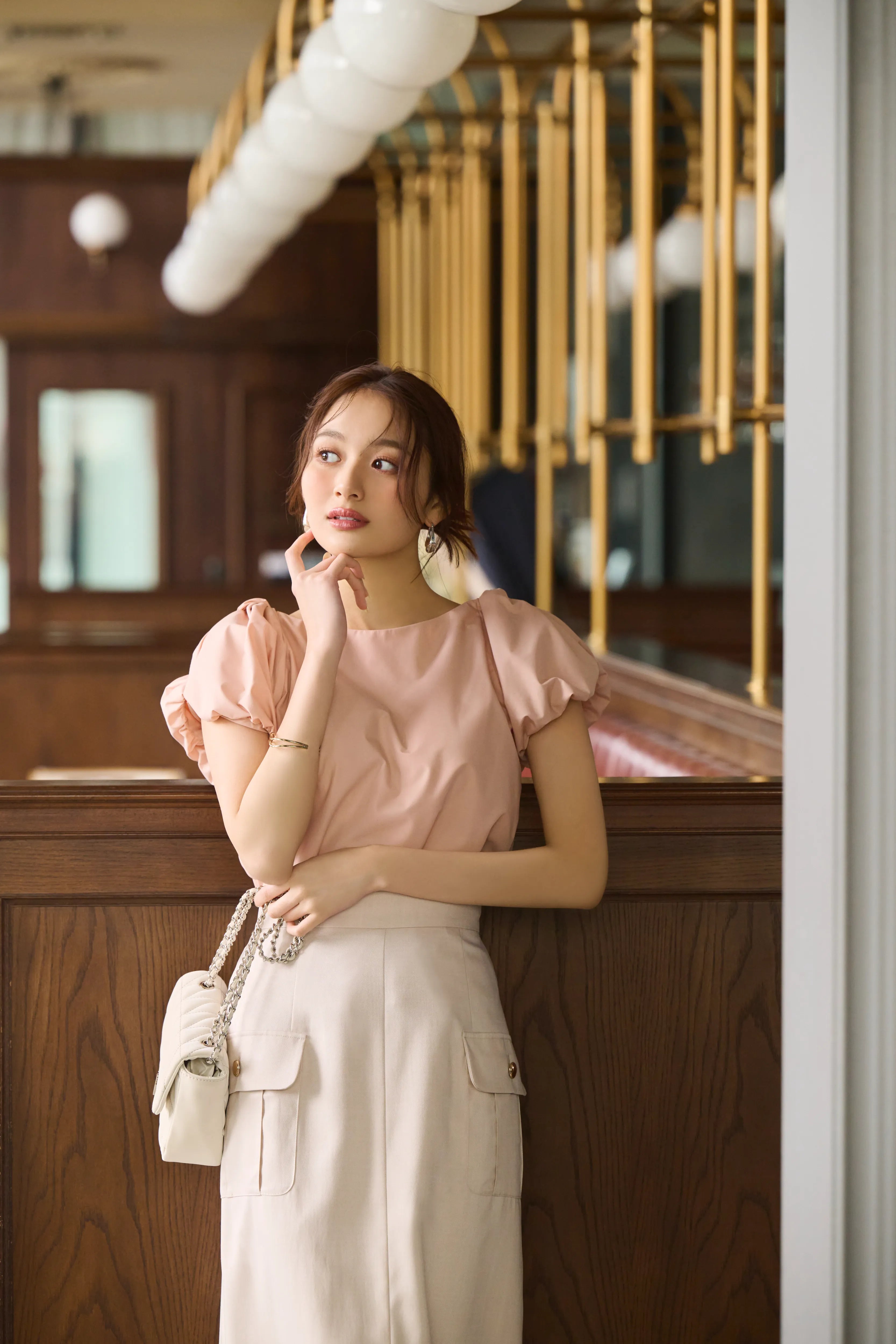 加藤栞さんが着るピンクのパフスリーブのトップスと白のスカートのスタイリング