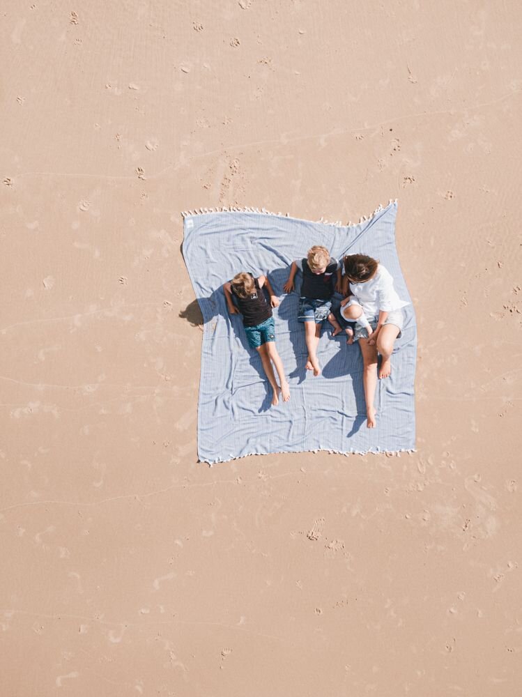 Family sharing a perfect holiday moment on their Ozoola family beach blanket