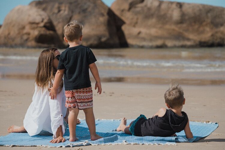Family using an Ozoola family beach blanket at the beach