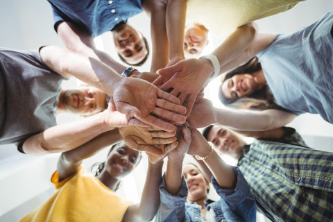 Group of people in a circle with hands together