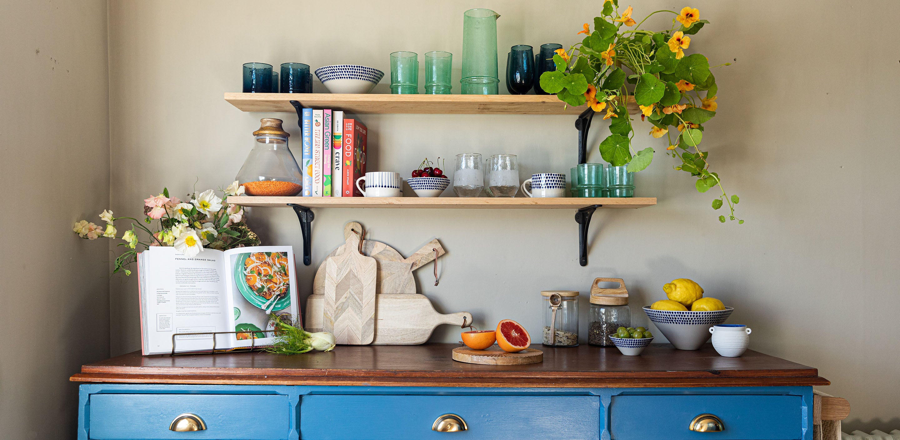 Blue kitchen dresser with shelves above and kitchenware