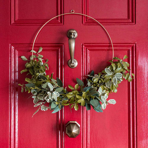 Half wreath on red front door with antique door fittings