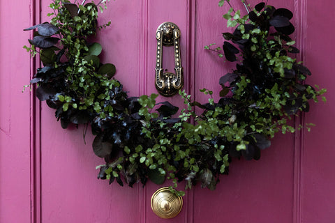 Festive wreath on pink front door 