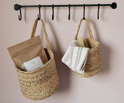 Pair of natural hemp woven baskets hanging on rail