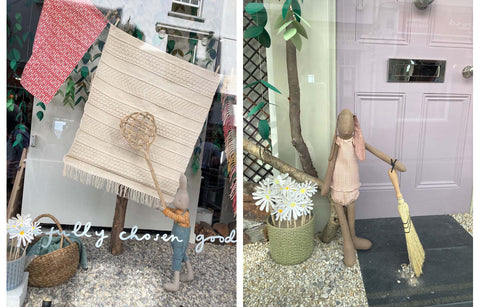 Summer window display with rugs and toy bunnies