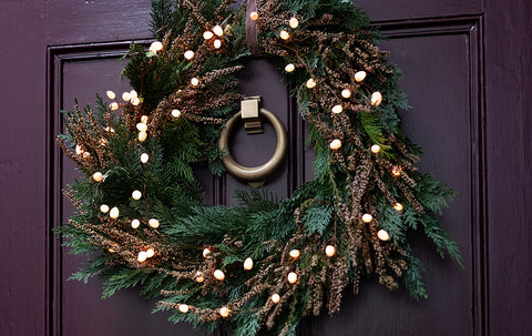 Traditional heather wreath on front door surrounding door knocker