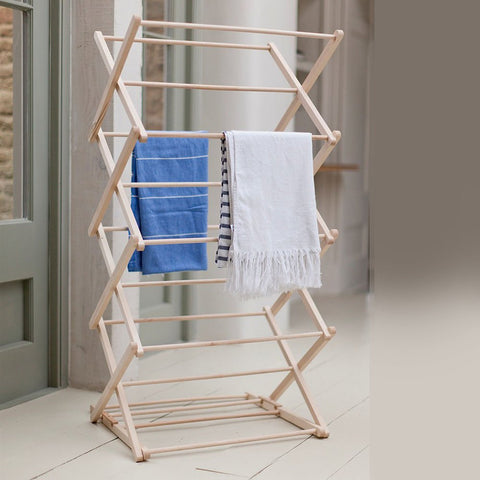 Upright wooden clothes horse airer with tea towels on