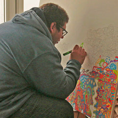 Disabled artist, Spencer Turner working on a large easel in the Art Box Arts art studio