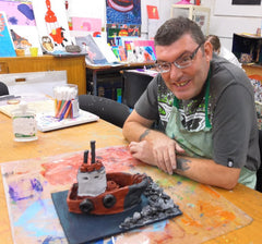 Disabled artist, Tony in art studio with clay sculpture