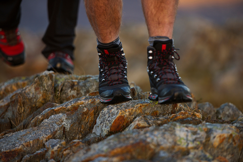 2 men with hiking shoes hiking on rocks